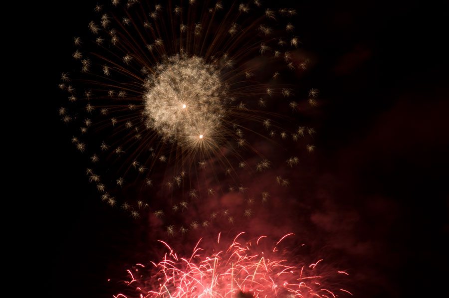 Red & gold fireworks explode in the night sky above Rockland County, New York.