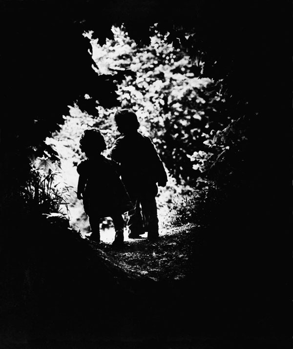 LIFE photographer W. Eugene Smith's children walk into a clearing.