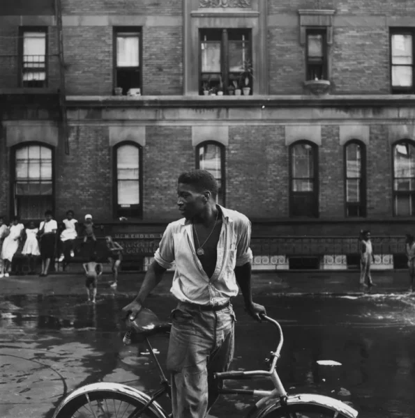 A Harlem gang leader stands next a bike by Gordon Parks.