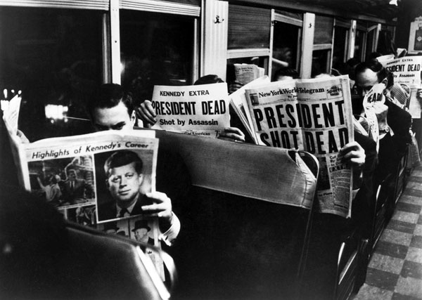 Commuters read about JFK assassination. Photo by LIFE photographer Carl Mydans.