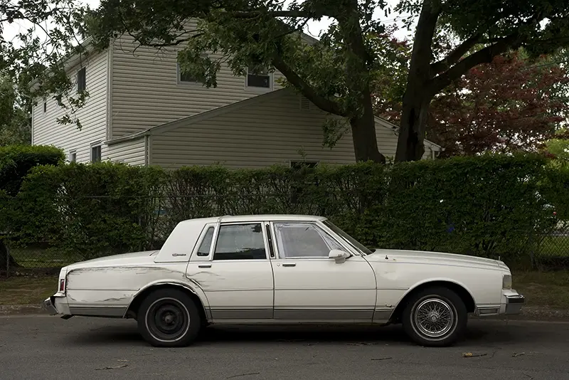 Old, beat-up white sedan in Orangeburg, New York, 2016.
