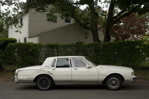 A beat-up old white sedan in Orangeburg, New York, 2016.