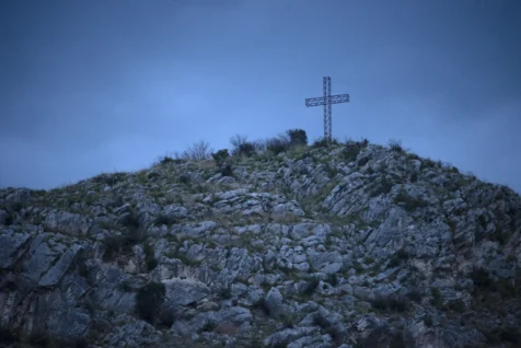A cross on a rocky hill at dusk in Tivoli, Italy, 2022.