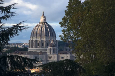 St. Peter's Basilica through trees in Rome, Italy, 2022.