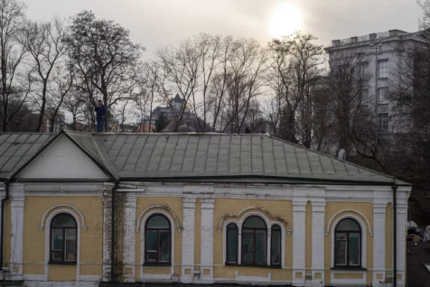 A man talks on the phone while standing on a roof near St. Anthony's church in Kyiv, Ukraine, 2020.