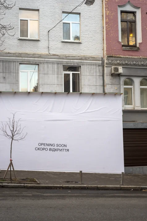 An opening soon sign near a building in Kyiv, Ukraine, 2019.