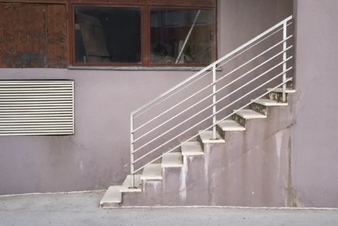 A staircase, vent and windows on a pastel pink building in Split, Croatia, 2019.
