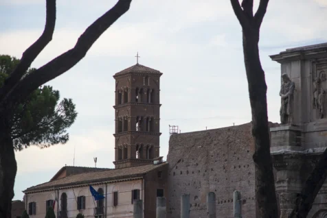A tower with a cross through trees in Rome, Italy, 2022.