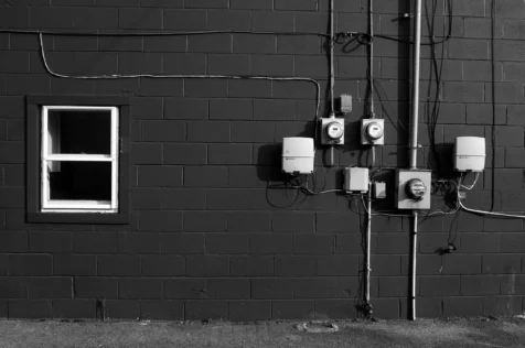 A window and electrical boxes on a brick building in Newburgh, New York, 2014.