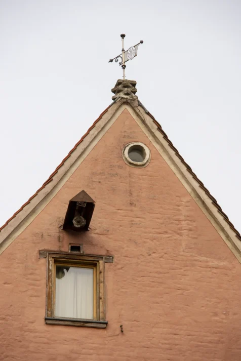 A brick building with a pulley near the window in Ulm, Germany, 2023.