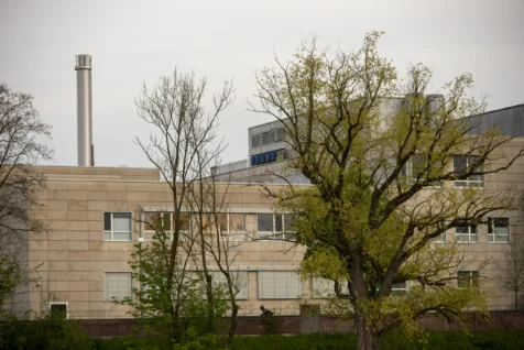 A building, cyclist and trees at dusk in Ulm, Germany, 2023.