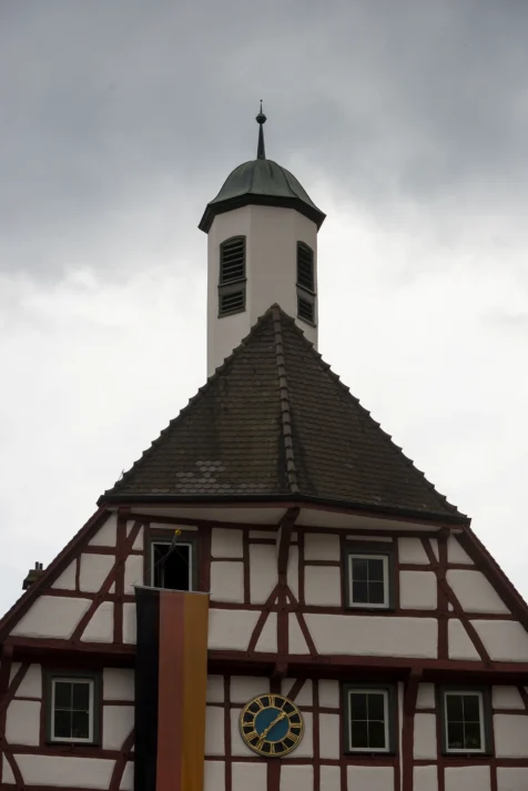 A building with a long German flag on a cloudy day in Blaubeuren, Germany, 2023.