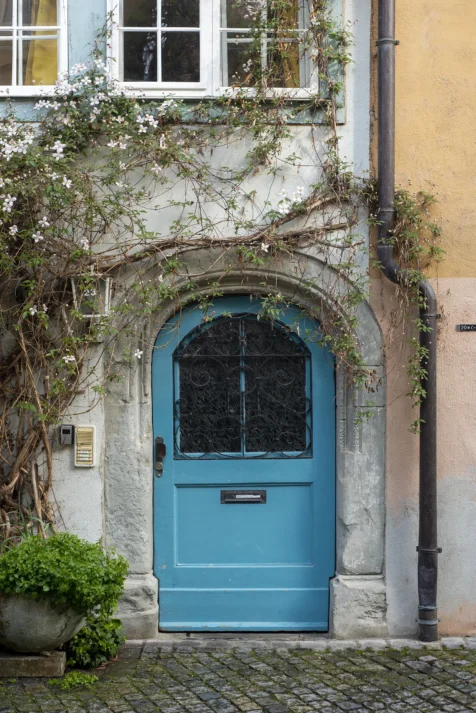 A charming blue door and blooming flowers in Lindau, Germany, 2023.