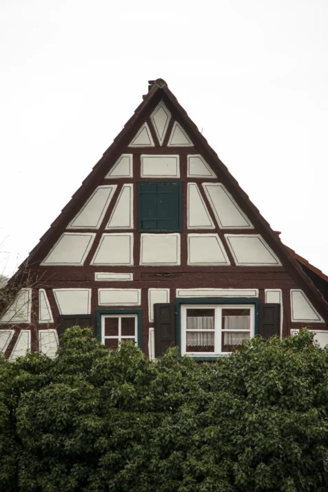 A charming brown and white house behind bushes in Blaubeuren, Germany, 2023.
