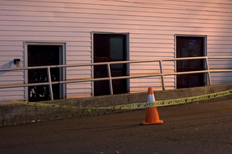 A building, cone and caution tape at night in Nyack, New York, 2015.