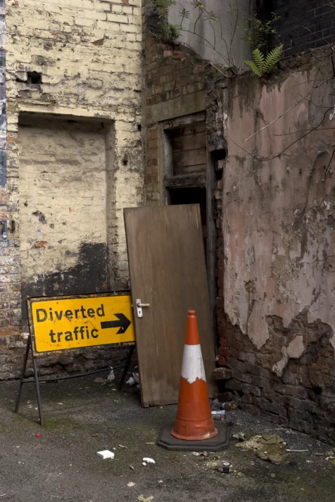 A diverted traffic sign next to a dilapidated building in Manchester, England, 2017.