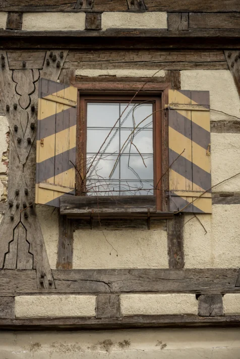 An exterior wall and unique black and yellow shutters on a building in Blaubeuren, Germany, 2023.