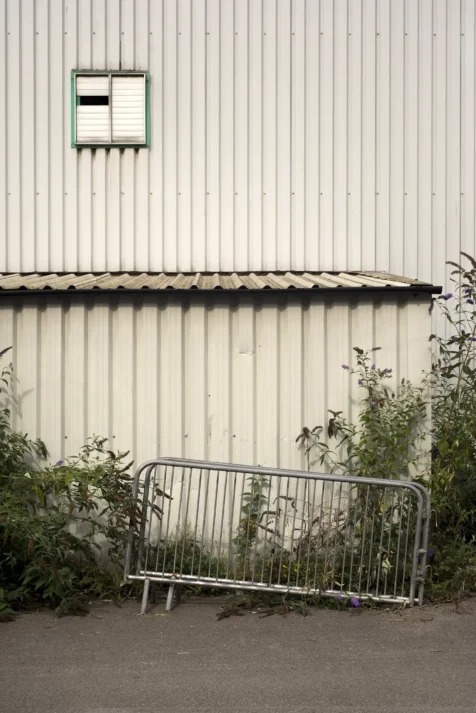 A metal barrier and plants outside a warehouse in Manchester, England, 2017.
