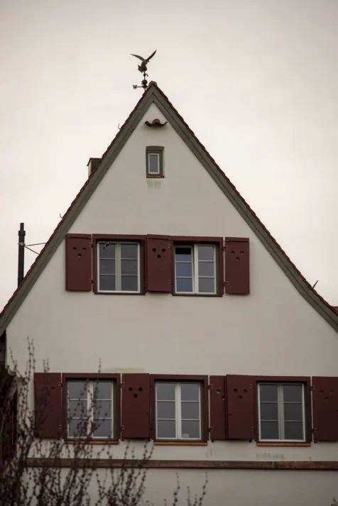 A building, cyclist and trees at dusk in Ulm, Germany, 2023.