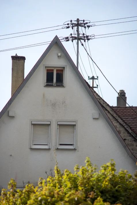 A house, power lines and bush in Geislingen an der Steige, Germany, 2023.