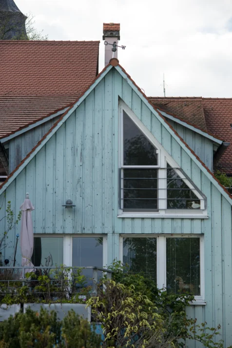 A light teal house and plants in Lindau, Germany, 2023.