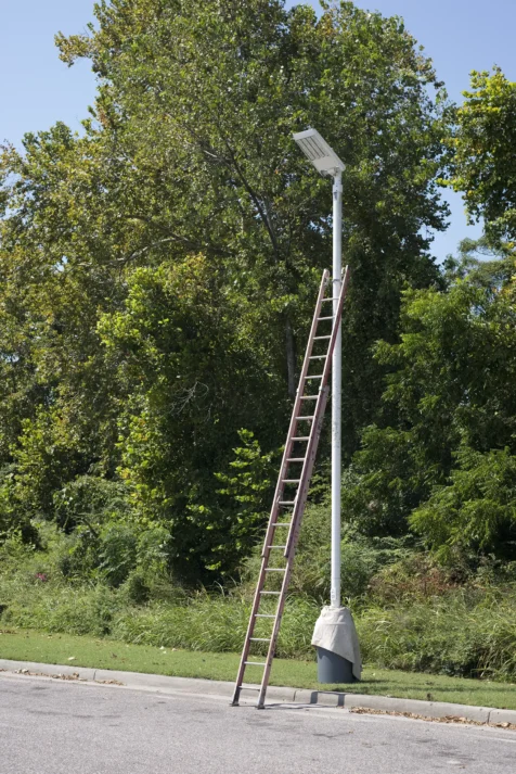 A tall ladder rests against a streetlight at a gas station somewhere in Florida, 2016.