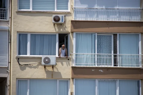 A man looks out his window on a sunny day in Antalya, Turkey, 2023.