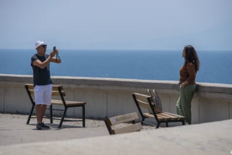 A man takes a portrait of a woman near the Mediterranean Sea in Antalya, Turkey, 2023.