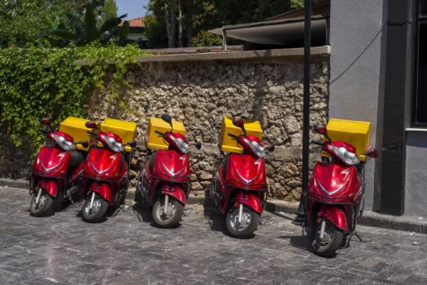 Five red and yellow McDonald's delivery scooters on a sunny morning in Antalya, Turkey, 2023.