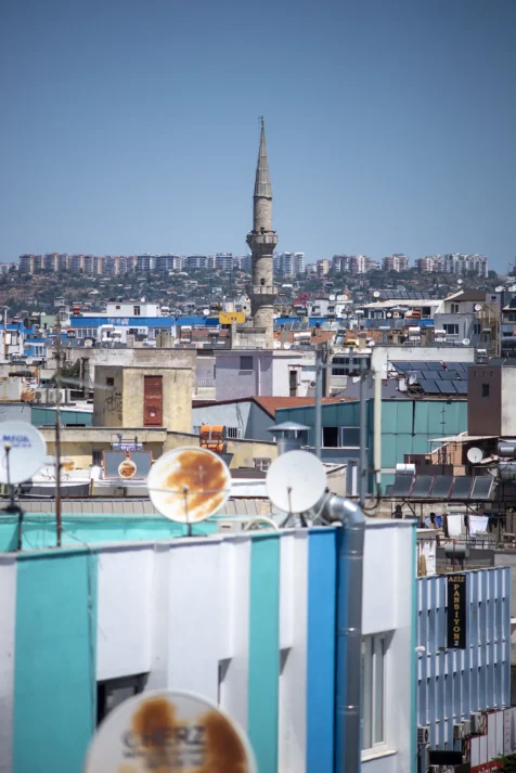 A mosque tower and assorted buildings on a sunny day in Antalya, Turkey, 2024.