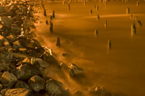 Rocks and old dock pylons in the Hudson River at night near Nyack, New York, 2013.
