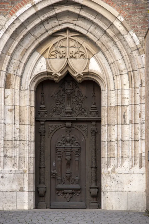 An ornate metal door on the Gothic cathedral in Ulm, Germany, 2023.