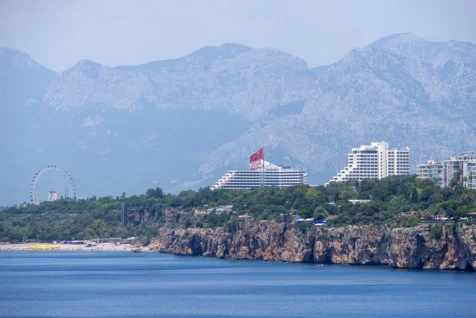 Resorts, mountains, cliffs, a ferris wheel, and a beach near the Mediterranean Sea in Antalya, Turkey, 2023.
