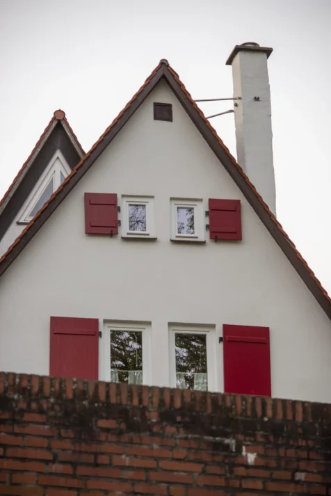 Two buildings behind a brick wall in Ulm, Germany, 2023.