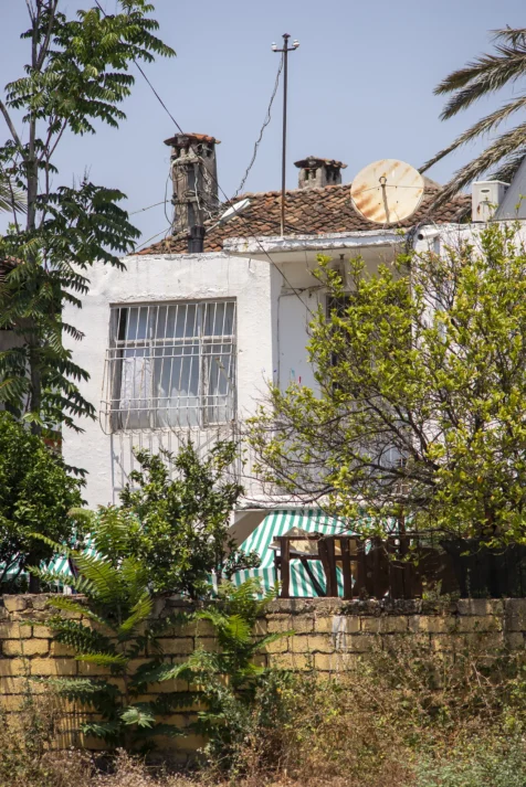 A white house, stone wall and plants in Antalya, Turkey, 2023.