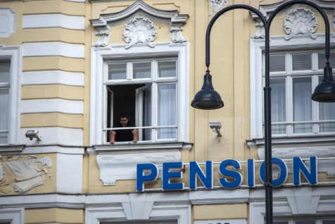 A man smokes a cigarette in a window in Vienna, Austria, 2023.