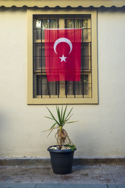 A Turkish flag hangs from a window in Old Town, Antalya, Turkey, 2024.