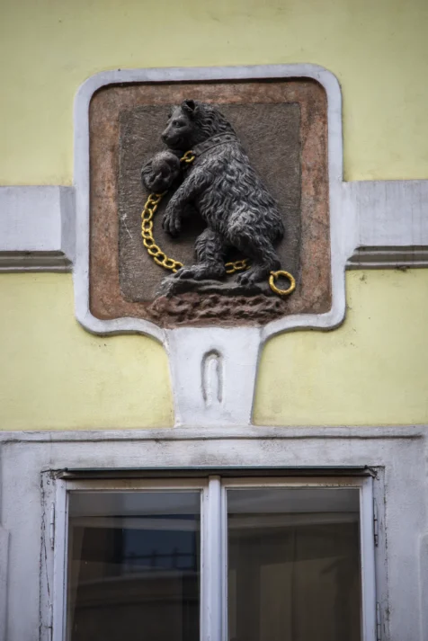 A bear on a leash on a building in Prague, Czech Republic.