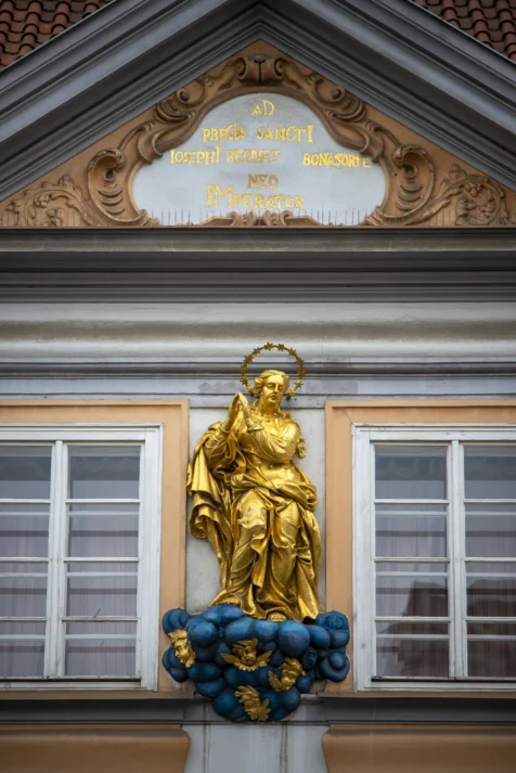 A golden statue on a building in Prague, Czech Republic.
