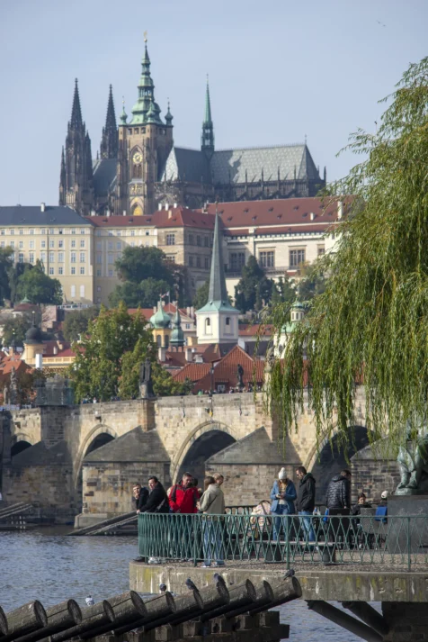 People stand near the river in Prague, Czech Republic.